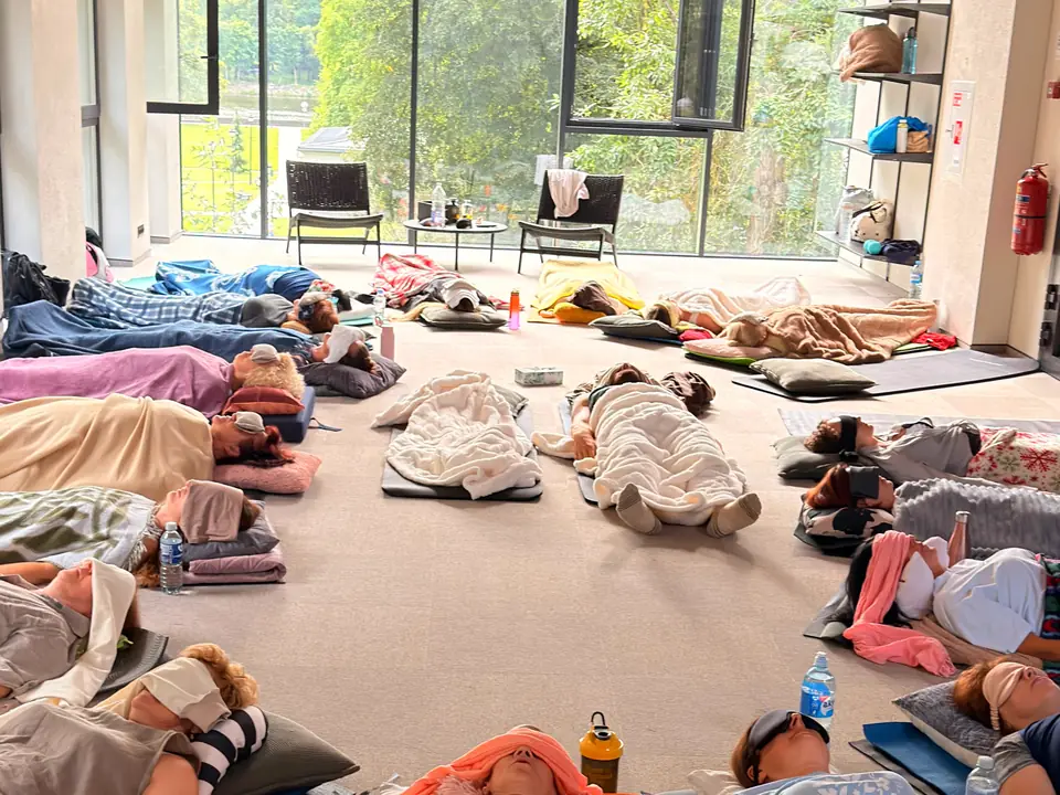 Une salle de séance : des personnes allongées sous des couvertures, les yeux fermés